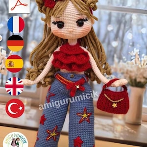 Puede incluir: Una muñeca tejida a ganchillo con cabello castaño rizado, un top rojo con volantes y pantalones azules decorados con aplicaciones de estrellas rojas y amarillas. La muñeca lleva una diadema roja con un lazo y un pequeño bolso rojo con cadena dorada. El texto amigurumicik es visible.