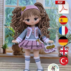 Puede incluir: Una muñeca de ganchillo con largo cabello castaño rizado, viste una chaqueta azul claro con botones dorados, falda plisada lavanda, calcetines blancos y zapatos grises. La muñeca sostiene un bolso a juego y lleva una diadema rosa. Texto amigurumicik.
