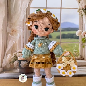 May include: A handmade crochet doll with brown hair adorned with white and yellow flower accents. The doll wears a green sweater, a yellow skirt, and white boots. It holds a matching purse decorated with flowers and a bow. The doll's name is "amigurumicik".