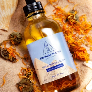 Puede incluir: Una botella de vidrio de aceite infundido con botánicos con un gotero. La botella está etiquetada "Kingdom of Kush Temple & Spa Slim Goddess Potion Botanical Infused Oil 118 ml e 4 oz."
