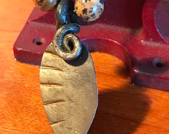 Sixth anniversary iron leaf pendant with six tally marks on the leaf.