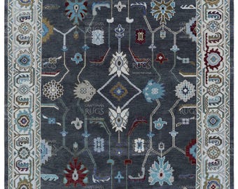 May include: A gray rug with a traditional Persian design featuring intricate floral patterns in shades of blue, red, and white. The rug has a cream-colored border with a geometric pattern.