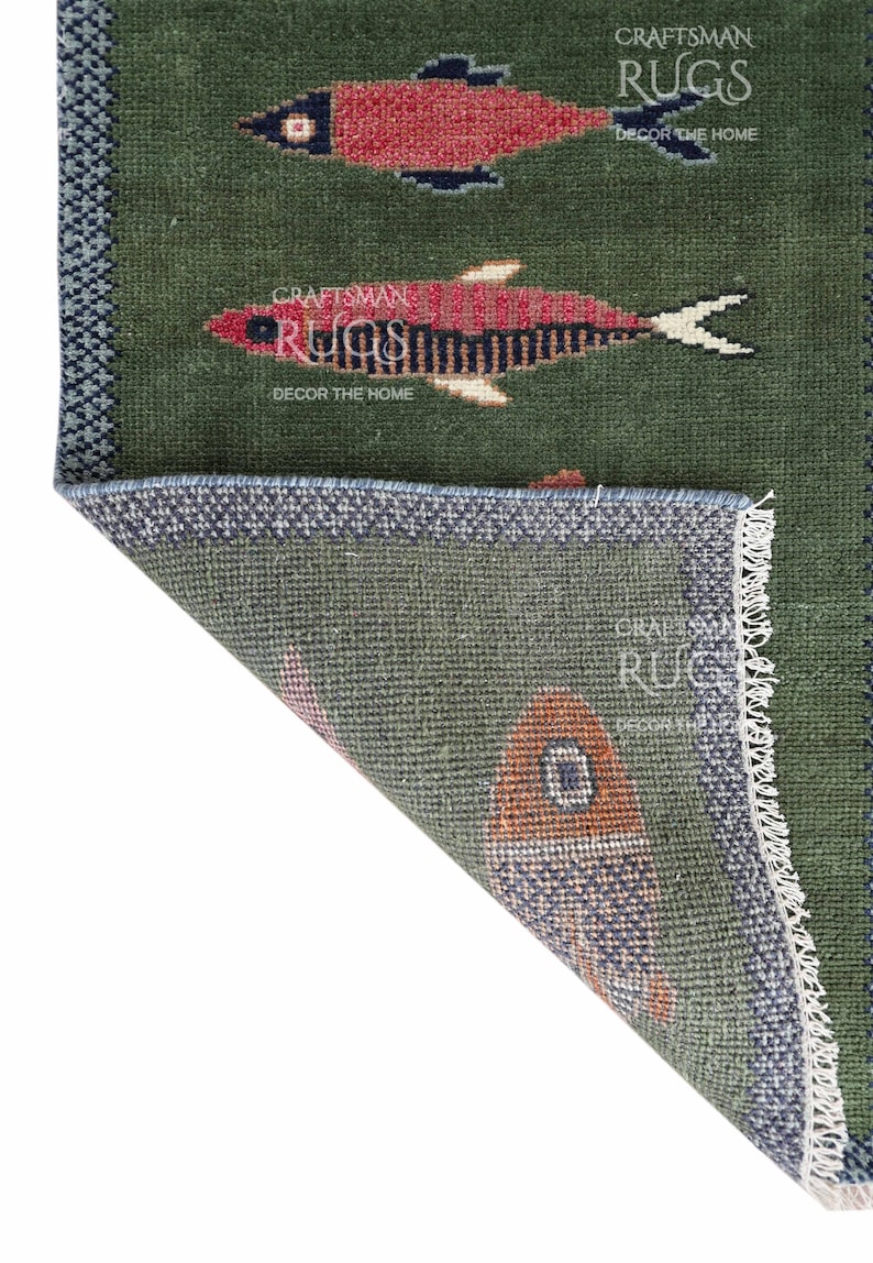 K&ouml;nnte beinhalten: Gr&uuml;ner Teppich mit Fischmuster. Der Teppich zeigt rote und schwarze Fischdesigns auf gr&uuml;nem Hintergrund. Der Teppich hat einen blauen Rand und den Text "CRAFTSMAN RUGS DECOR THE HOME".
