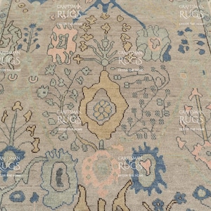 May include: A close-up of a beige rug with an elaborate floral design. The pattern includes blue, pink, and yellow elements. The rug's border has a matching pattern, enhancing the overall look. This rug is suitable for home decor and measures in centimeters.