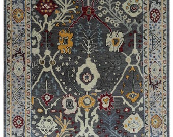 May include: A gray rug with a floral pattern in shades of red, yellow, and blue. The rug has a border with a geometric pattern.