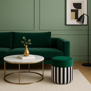 Op de afbeelding: Een woonkamer met een donkergroene fluwelen bank, een ronde salontafel met een marmeren blad en een gouden frame, en een gestreepte poef. Een gouden vaas met groen staat op de tafel. Een zwarte vloerlamp en kunstwerk maken de scène compleet.