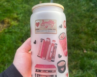 May include: A frosted glass tumbler with a bamboo lid and a clear straw. The tumbler is decorated with red and black hearts, stacks of books, and the words "Smotty Book Club" and "forbidden love."