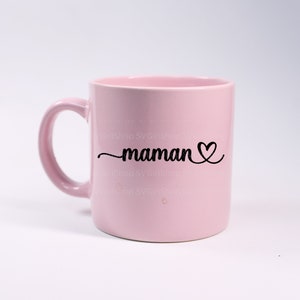 May include: A pink ceramic mug with a black design that says "maman" with a heart.