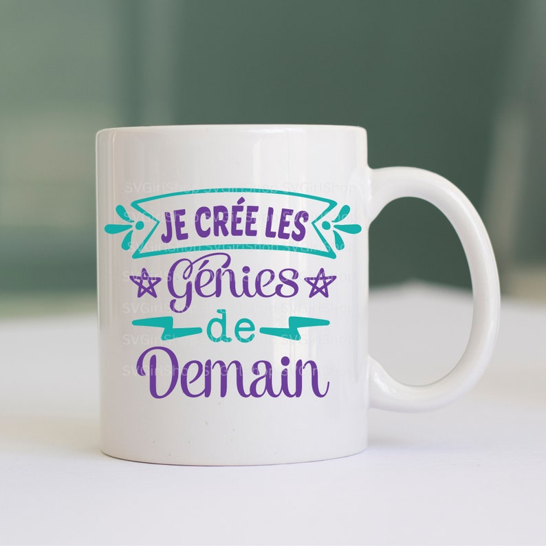 May include: White ceramic mug with a teal and purple design. The text on the mug reads "Je cr&eacute;e les g&eacute;nies de demain".