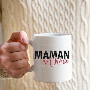 May include: White ceramic mug with a black and red design that says "Maman Ch&eacute;rie" with three red hearts.