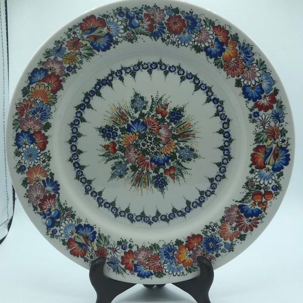 Decorative handpainted plate floral design with blue,orange,red,and many more colors is signed by maker