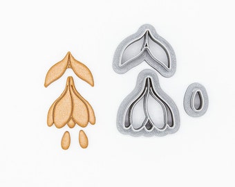 May include: A set of 3D printed cookie cutters in the shape of a flower. The cutters are made of plant-based plastic and are non-toxic. The cutters are in the colours of gold and silver.