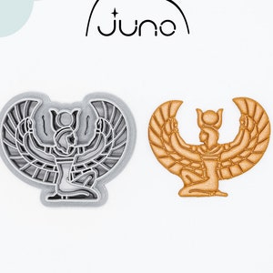 Op de afbeelding: Een 3D-geprinte koekjesuitsteker in de vorm van een Egyptische godin met uitgespreide vleugels. De uitsteker is in grijs en goud getoond.