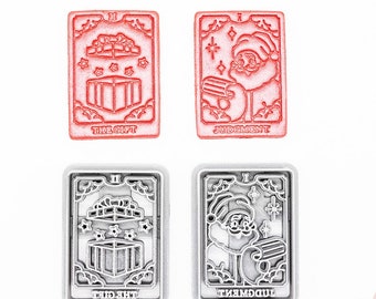 May include: Four rectangular cookie cutters with tarot card designs. Two are red, featuring "The Gift" and "Judgment" with festive illustrations. The other two are silver, mirroring the designs. The text "3D PRINTED cutter" and "PLA plant-based plastic, non-toxic" are also visible.