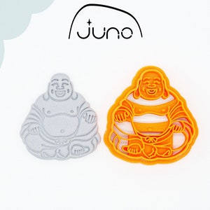 Può includere: Due stampini per biscotti stampati in 3D a forma di Buddha. Lo stampino a sinistra è grigio e quello a destra è arancione.