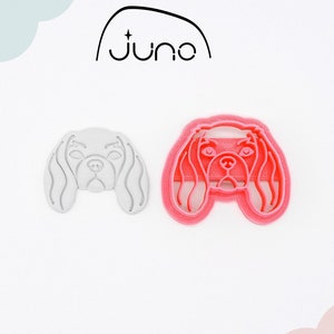 May include: A 3D printed cookie cutter in the shape of a Cavalier King Charles Spaniel dog head. The cutter is made of PLA plant-based plastic and is non-toxic. The cutter is shown in both a white and a pink color.