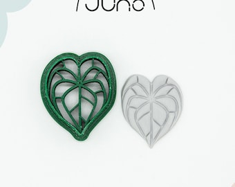 May include: A green 3D printed cookie cutter in the shape of a heart-shaped leaf. The cutter is made of PLA plant-based plastic and is non-toxic. A white version of the cutter is also shown.