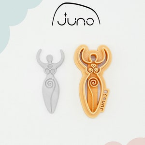 May include: A 3D printed cookie cutter in the shape of a woman with raised arms and intricate designs. The cutter is made of PLA plant-based plastic and is non-toxic. The cutter is light gray and is shown next to a similar cutter in a light orange color.