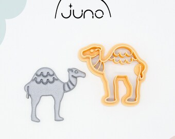 May include: Two 3D printed cookie cutters in the shape of camels. The larger camel is orange and the smaller camel is silver.
