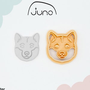 May include: A 3D printed cookie cutter in the shape of a dog's head. The cutter is made of PLA plant-based plastic and is non-toxic. The cutter is shown in both its natural white color and a light brown color.