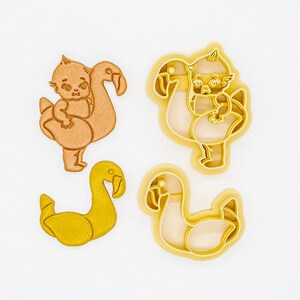 Puede incluir: Conjunto de cuatro cortadores de galletas impresos en 3D hechos de plástico vegetal PLA. Los cortadores tienen forma de flamenco con un bebé encima, un flamenco con un bebé encima, un cisne y un cisne. Los cortadores son no tóxicos.