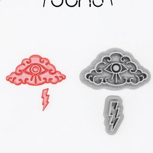 May include: Two 3D printed cookie cutters, one gray and one red, shaped like a cloud with an eye and a lightning bolt. The text "3D PRINTED cutter" and "PLA plant-based plastic, non-toxic" is visible below the cutters.