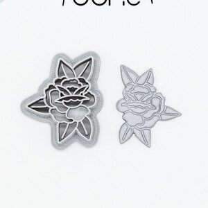 Op de afbeelding: Twee 3D-geprinte koekjesvormen in de vorm van een roos, een groter dan de andere, gemaakt van PLA-plantenplastic. De vormen zijn niet-toxisch en zijn ideaal voor het maken van mooie koekjes.