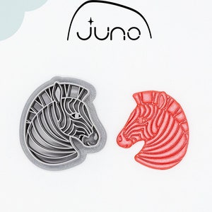 Puede incluir: Dos cortadores de galletas de cabeza de cebra impresos en 3D. Uno es gris y el otro es rojo. Los cortadores están hechos de plástico vegetal PLA y son no tóxicos. CORTADOR IMPRESO EN 3D Plástico vegetal PLA, no tóxico