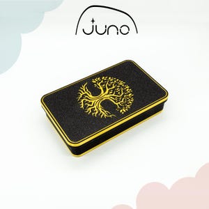 May include: Black rectangular box with a gold trim and a gold tree of life design. The box is labeled "Juno" on the top.