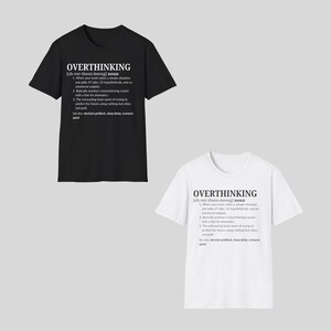 以下が含まれることがあります： 黒と白の2枚のTシャツ。それぞれに白い文字で「OVERTHINKING」と書かれています。その下に、考えすぎることの定義があります。Tシャツは半袖で、綿でできているようです。