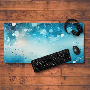 May include: A blue and white abstract design mousepad with a black keyboard and black headphones on a wooden surface.