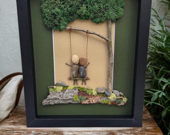 Framed Pebble Art - Couple on a Swing with green and sand background