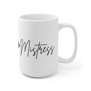 May include: White ceramic mug with a curved handle. The mug features the word "Mistress" in black cursive script. The mug is a standard size for coffee or tea.