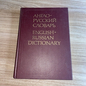 Op de afbeelding: Een bordeauxkleurig hardback boek met gouden letters op de voorkant. De titel is "Anglo-Russian Dictionary" en "English-Russian Dictionary".