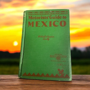 以下が含まれることがあります： マイケル＆ヴァージニア・スカリー著「Motorists' Guide to MEXICO」というタイトルの緑色の本。本は茶色の縁取りに装飾的な模様が施され、右下隅には車の小さなイラストが描かれている。
