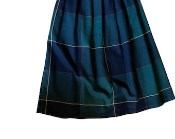 May include: A pleated skirt with a plaid pattern in shades of green, blue, and yellow.