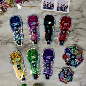 Pode incluir: Um conjunto de sete adesivos holográficos com os membros do grupo de K-pop BTS. Cada adesivo é um microfone de uma cor diferente e com o nome de um membro. Há também dois adesivos menores com um design circular que apresenta o logotipo do BTS e os microfones.