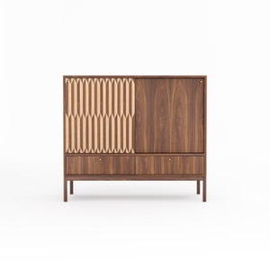 May include: A mid-century modern walnut wood cabinet with two drawers and two sliding doors. One door features a geometric pattern of light wood.