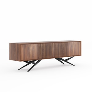 Puede incluir: Un centro de entretenimiento moderno de madera de nogal con patas de metal negro. El gabinete tiene tres puertas, dos sólidas y una con listones verticales.