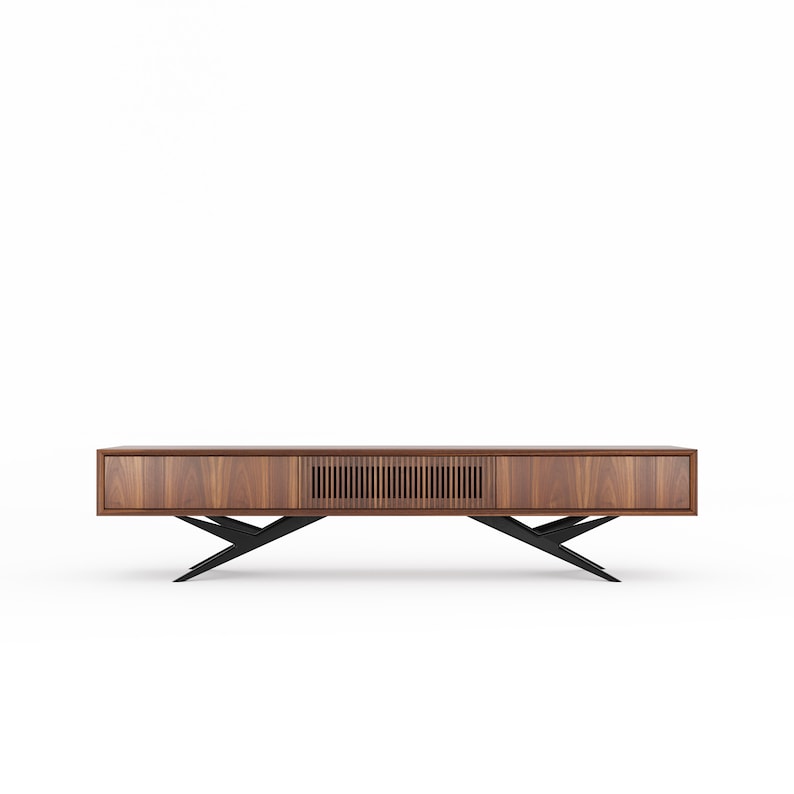 May include: A contemporary media unit in warm-toned wood, featuring a linear grain. It has two drawers and a slatted centre section. The unit is supported by a black, angular metal base, giving a floating effect. The design is minimalist and modern, suitable for a living room.
