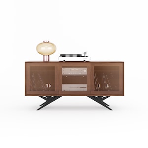 Peut inclure: Un meuble de divertissement en bois foncé avec trois portes à lattes et une étagère en verre. Le meuble a des pieds en métal noir et une platine vinyle sur le dessus.