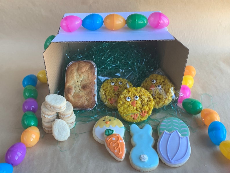 Items included in the gluten free Easter Treat Box include mini mandarin cardamom pound cake, decorated easter sugar cookies, 3 brown butter & sea salt treats in the shape of chicks and 6 lemon and pistachio shortbread