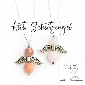 Könnte beinhalten: Zwei silberne Engelsanhänger mit rosafarbenen und pfirsichfarbenen Perlen. Die Anhänger hängen an silbernen Ketten. Der Text auf der Karte lautet: "Ich bin dein Auto-Schutzengel und passe immer gut auf dich auf!"
