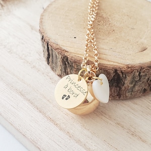 Personalized pregnancy bola in gold or silver color, mother-of-pearl heart, customizable engraving on medal. Pregnancy gift