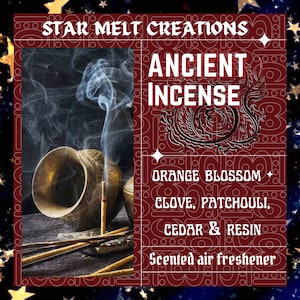 May include: A brown and gold incense burner with smoke rising from it. The incense sticks are arranged around the burner. The image has the text "STAR MELT CREATIONS ANCIENT INCENSE ORANGE BLOSSOM CLOVE, PATCHOULI, CEDAR & RESIN Scented air freshener".