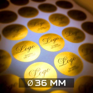 Può includere: Adesivi ovali in lamina d'oro con la parola "Logo" in elegante scrittura, insieme a un nome e un numero di telefono. Gli adesivi hanno un diametro di 3,6 cm. Gli adesivi sono disposti a griglia.