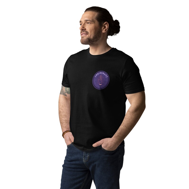 Op de afbeelding: Een zwart T-shirt met een paarse en rode ronde afbeelding met de tekst "CRIBONAUT" in wit.