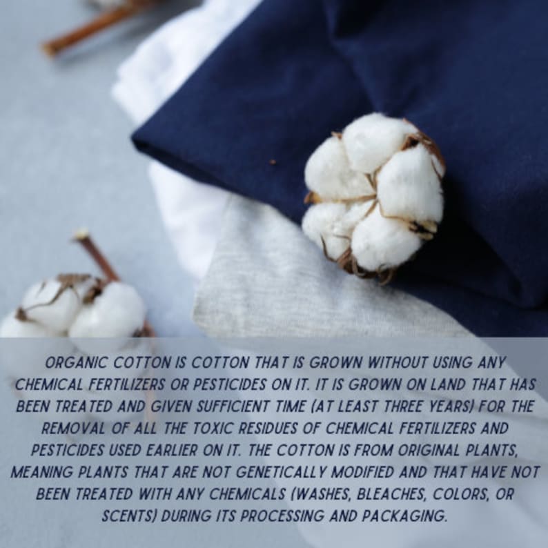 Op de afbeelding: Een close-up van een stapel witte en blauwe stof met een katoenen bol er bovenop. De tekst luidt "ORGANIC COTTON IS COTTON THAT IS GROWN WITHOUT USING ANY CHEMICAL FERTILIZERS OR PESTICIDES ON IT. IT IS GROWN ON LAND THAT HAS BEEN TREATED AND GIVEN SUFFICIENT TIME (AT LEAST THREE YEARS) FOR THE REMOVAL OF ALL THE TOXIC RESIDUES OF CHEMICAL FERTILIZERS AND PESTICIDES USED EARLIER ON IT. THE COTTON IS FROM ORIGINAL PLANTS, MEANING PLANTS THAT ARE NOT GENETICALLY MODIFIED AND THAT HAVE NOT BEEN TREATED WITH ANY CHEMICALS (WASHES, BLEACHES, COLORS, OR SCENTS) DURING ITS PROCESSING AND PACKAGING."