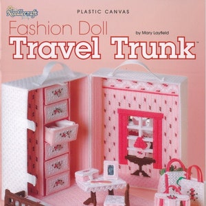 May include: A pink plastic canvas craft kit for a dollhouse travel trunk. The kit includes a pink and white patterned trunk with a handle, a pink and white patterned bedroom, a pink and white patterned closet, a pink and white patterned table and chairs, and a pink and white patterned bed. The kit also includes a pink and white patterned suitcase and a pink and white patterned purse. The kit is titled "Fashion Doll Travel Trunk" and is by Mary Layfield. The kit number is 847501.