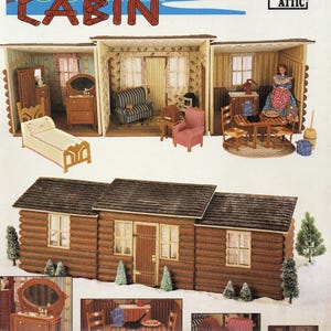 Pode incluir: Um kit de casa de bonecas em tela plástica com as palavras "COUNTRY CABIN". O kit inclui uma cabana de madeira em miniatura e vários quartos mobiliados, incluindo um quarto, sala de estar e área de jantar. Da Annie's Attic.